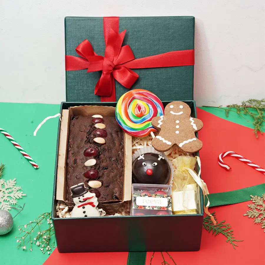 Sweet Celebration Gift Box with plum cake, assorted chocolates, salted cranberry dragees, sugar lollipop, snowman, gingerbread cookie, and hot chocolate bomb