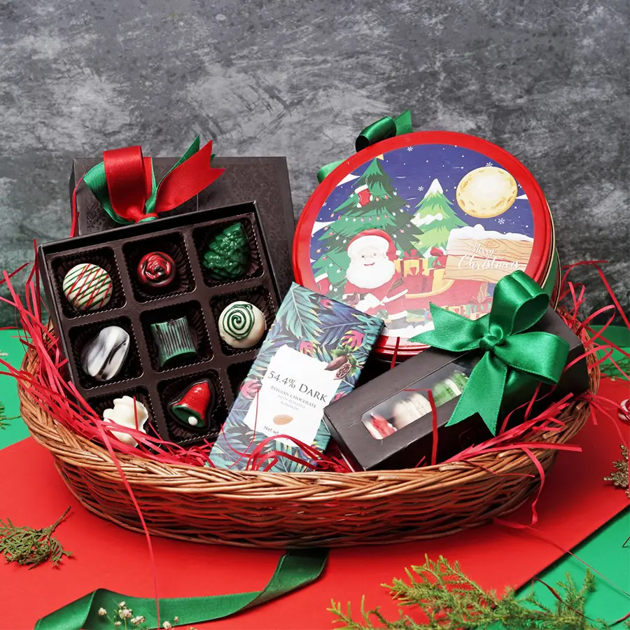 Xmas Delightful Delicacies Basket filled with dark Belgian chocolate, crunchy almonds, festive Christmas chocolates, colorful macarons, and a tin of moist plum cake