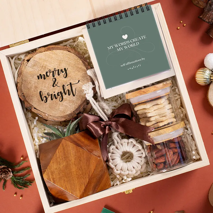 Thoughtful Treasures Gift Box featuring wooden coasters, affirmation flip, Star Flake Cookie Jar, Barbeque Almonds, wooden planter, macrame ornaments, and a reusable pinewood box.