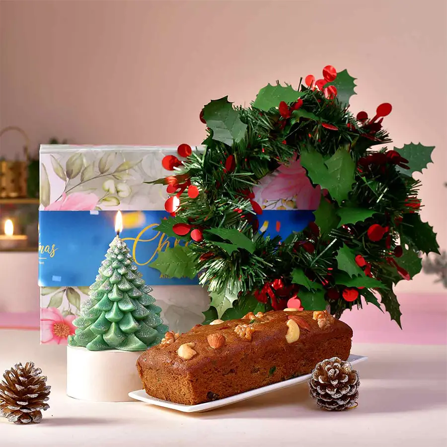 Christmas Elegance Ensemble hamper featuring a tree-shaped scented candle, plum cake, Christmas wreath, and stylish gift box with holiday sleeve.