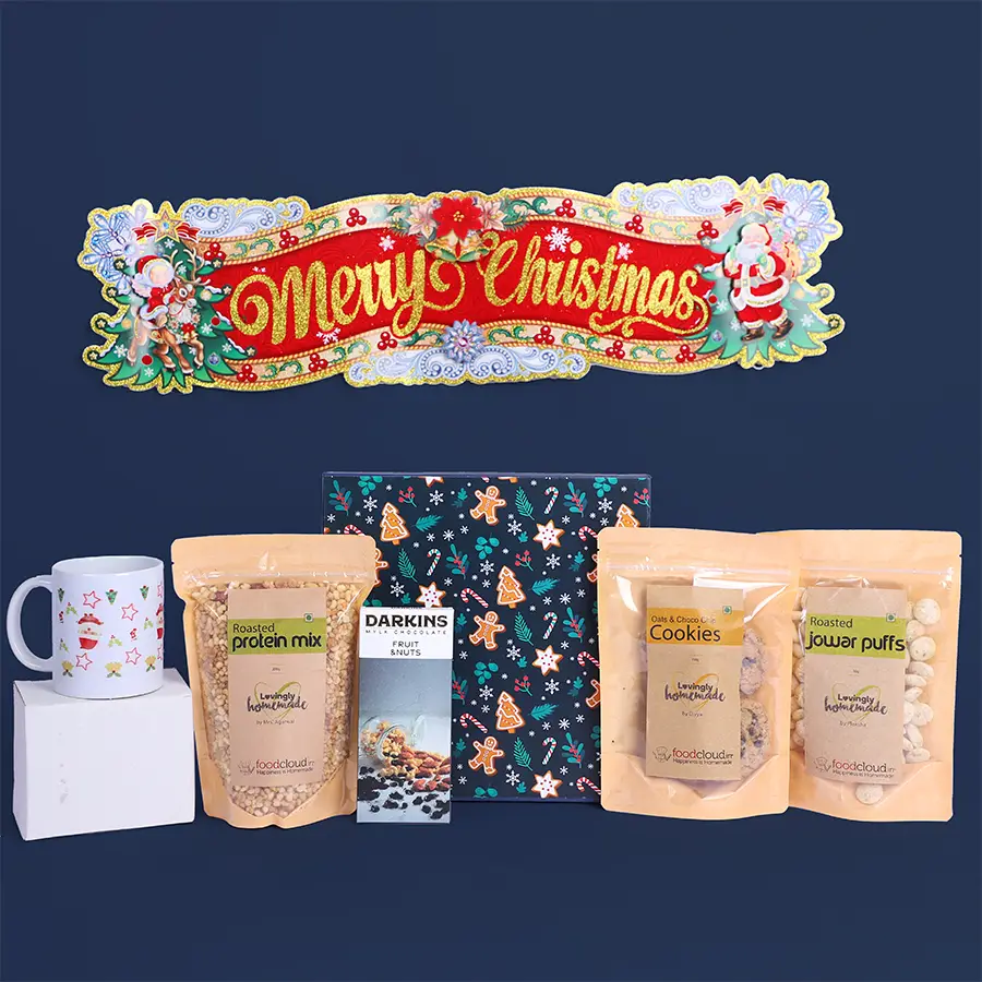 Ultimate Christmas Treats Symphony Box featuring vegan milk chocolate, cookies, protein mix, jowar puffs, a festive mug, and a hanging tag.