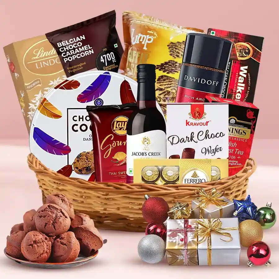 Flavourful Christmas Indulgence Hamper featuring Jacobs Creek Non-Alcoholic Shiraz, Ferrero Rocher, Lindt Lindor chocolates, Twinings English Breakfast Tea, Sapphire Chocoship Cookies, Lays Gourmet Sweet Chilli Chips, beautifully gift-wrapped in a festive basket.