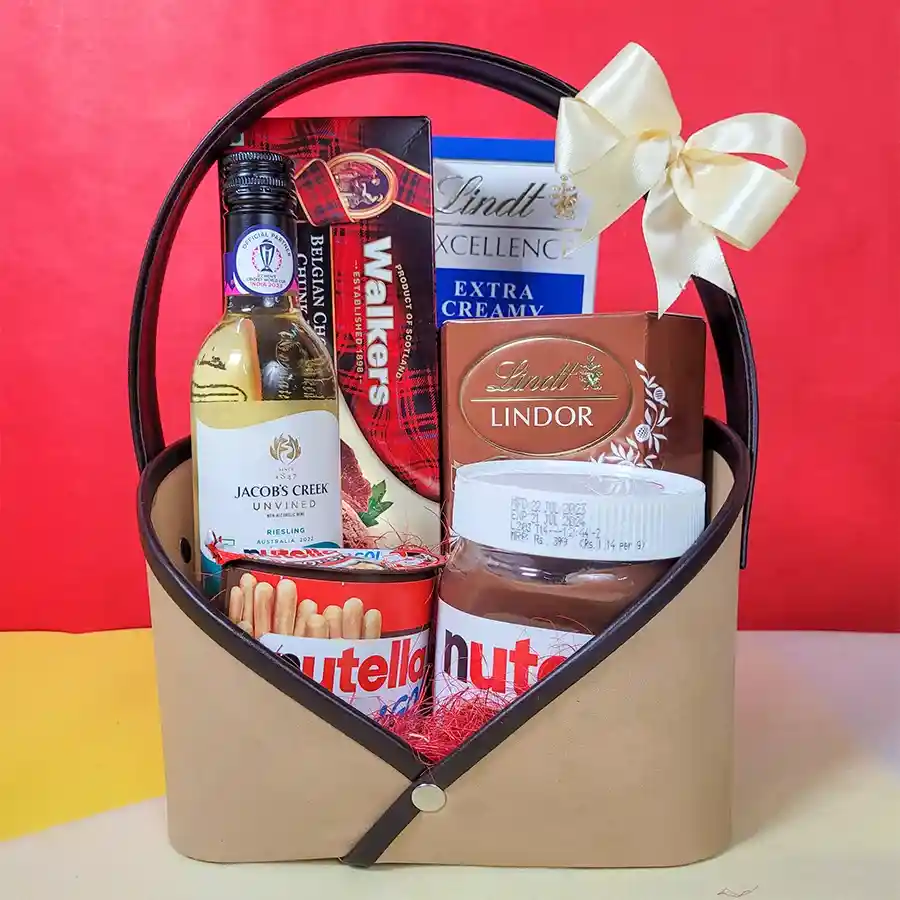 Christmas Sip N Savor Collection hamper featuring Jacobs Creek Non-Alcoholic Riesling, Walkers Belgian Chocolate Chunk Biscuits, Lindt Lindor Hazelnut Truffles, Lindt Excellence Milk Chocolate, Nutella Hazelnut Spread, Nutella Bread Sticks, and a reusable designer tote bag.