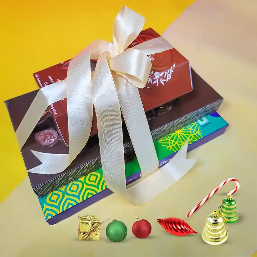 Gourmet Chocolate Celebration Tower featuring Cadbury Celebrations, handmade dry fruit chocolates, and Lindt Lindor Hazelnut Truffles, elegantly gift-wrapped with a ribbon.