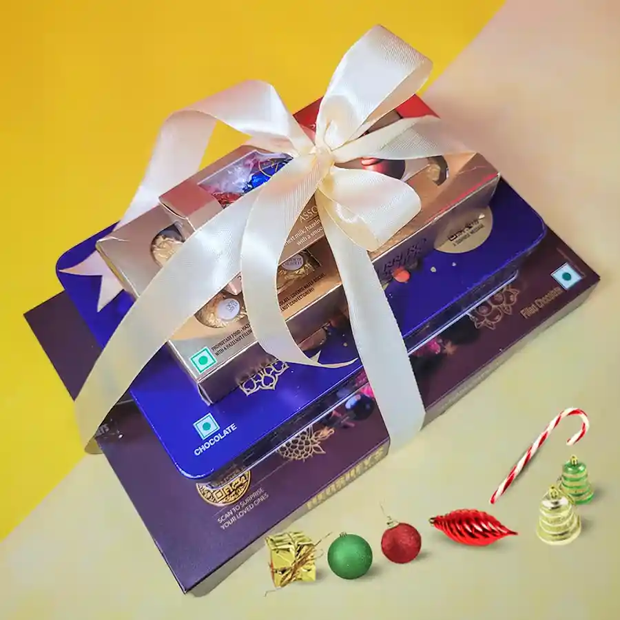 Exotic Chocolaty Symphony Tower filled with Hershey’s Dark Chocolates, Cadbury Dry Fruit treats, Ferrero Rocher, and Lindt Lindor Hazelnut Truffles, elegantly gift-wrapped with a ribbon.