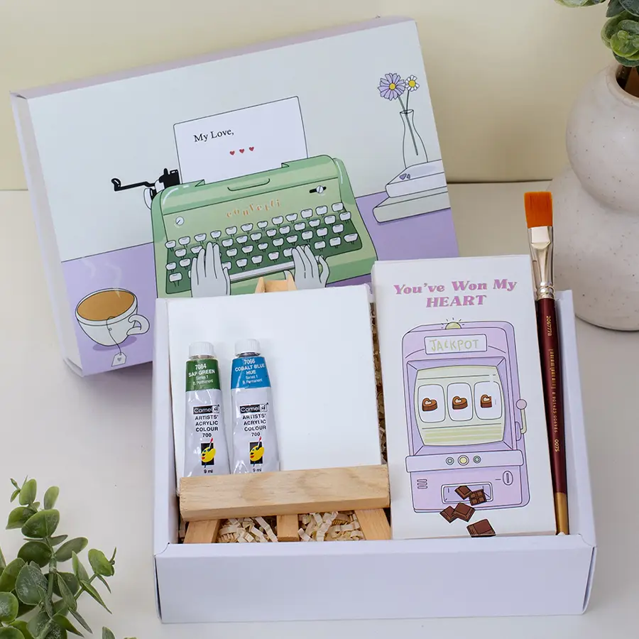 Artistic Gifts N Chocolates Hamper featuring a small canvas, easel, paint tubes, paintbrush, "You Have My Heart" chocolates, and a fun slider box filled with treats.