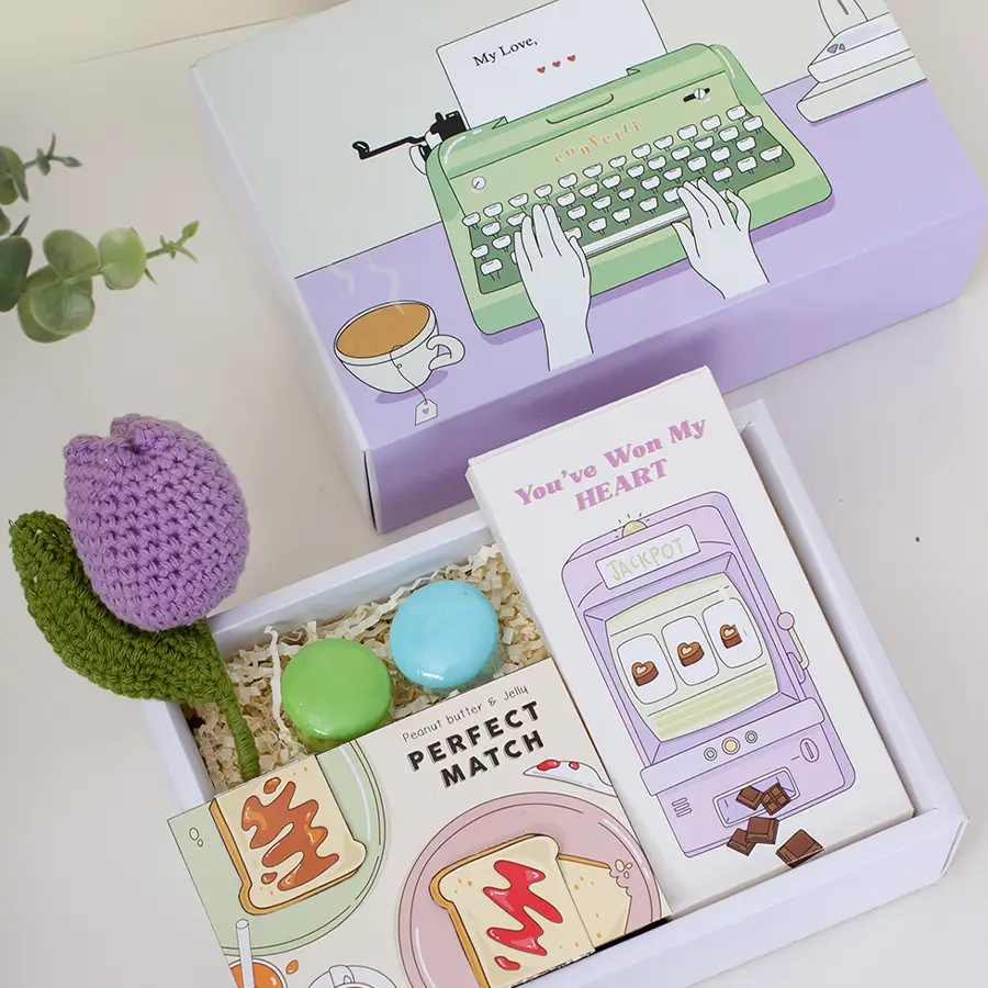 Heartfelt Valentines Delight Hamper featuring a crocheted tulip, two macaroon soaps, a stylish bookmark, chocolates, and a sleek slider box.