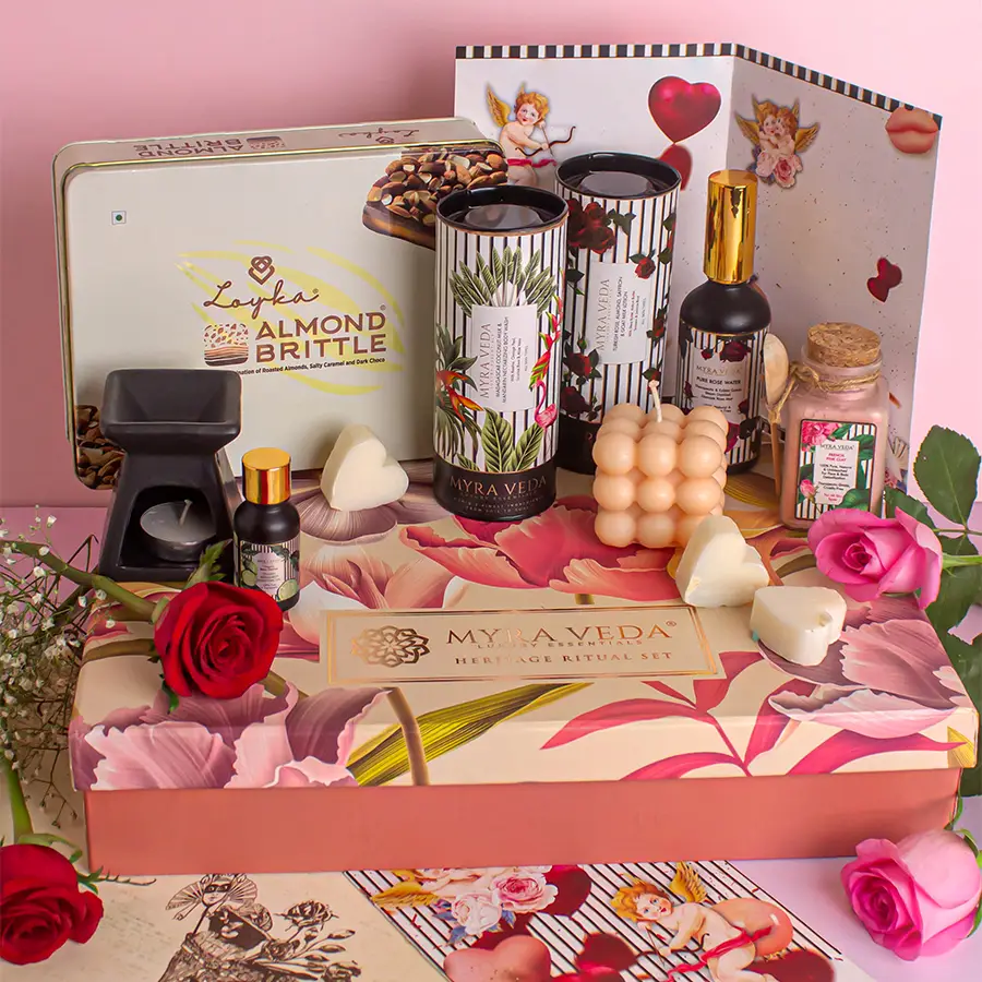Gift box containing Italian Bergamot Essential Oil, a diffuser, a tea light candle, almond brittle chocolates, goat milk lotion, coconut body wash, rose water, organic clay, a vegan bubble candle, and a personalized Valentine’s card.