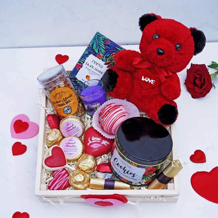 Love N Luxuries Chocolates Gift Box featuring heart-shaped lollipops, dark Belgian chocolate, almond florentines, hot chocolate bomb, scented candle, and Italian masala mix.