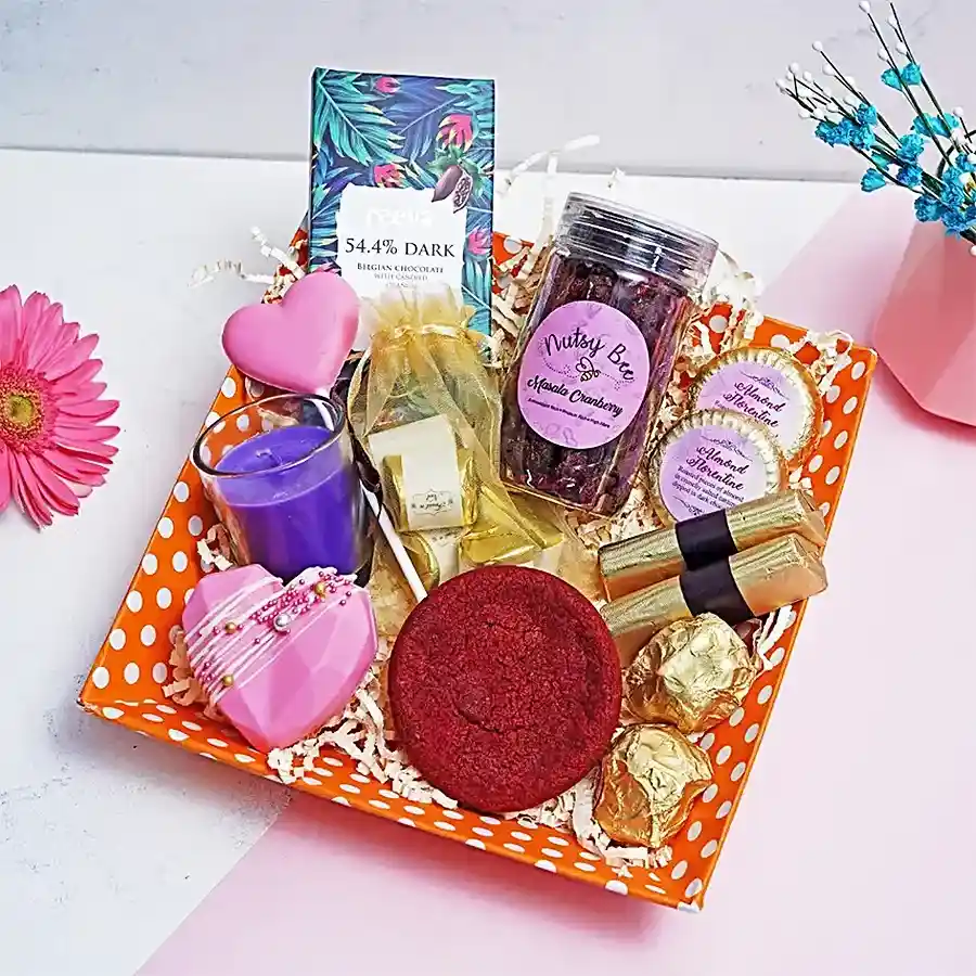 Luxury Delights Gift Tray filled with gourmet treats including dark chocolate, hot chocolate pinatas, red velvet cookies, fine chocolates, masala cranberry bottles, and almond rocks.