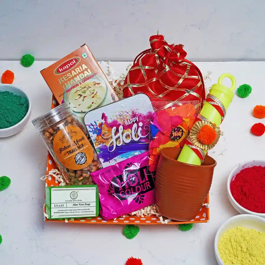 Ultimate Festive Fusion Hamper featuring Kesar Thandai, Italian Masala Trail Mix, Strawberry Crisp Logs, Khadi Aloe Vera Soap, Kullad Cup, Holi powders, balloons, Pichkari, and Happy Holi coaster.