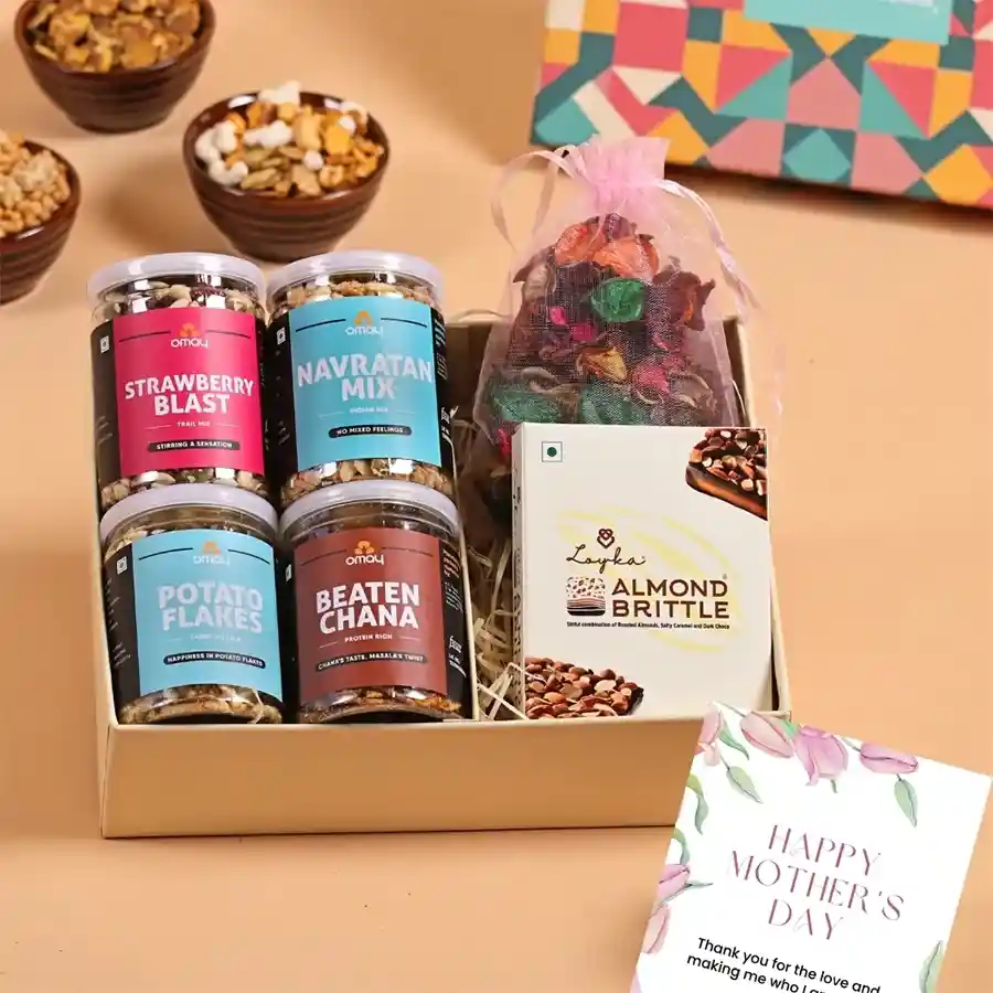 Mother's Day Bliss Gift Box featuring an assortment of treats including Strawberry Blast, Beaten Chana, Navratan Mix, Potato Flakes, Loykas Chocolate Almond Brittle, scented potpourri, and a greeting card, all presented in a premium box.