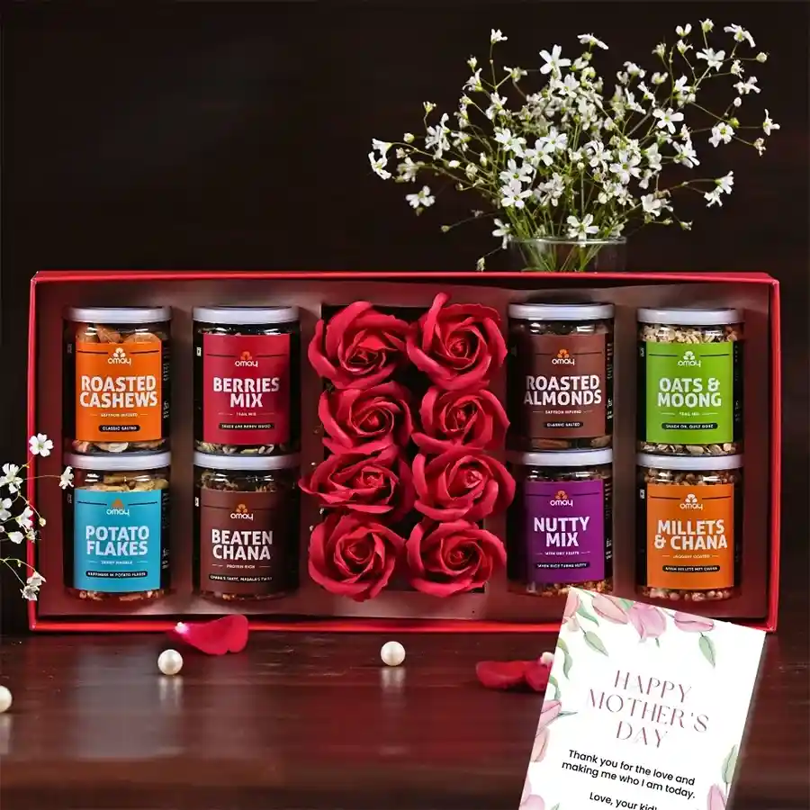 Mother's Day Special Pamper Hamper with gold-foiled packaging, filled with sweet Berries Mix, crunchy Roasted Almonds and Cashews, wholesome Oats N Moong, artificial flowers, and a greeting card.