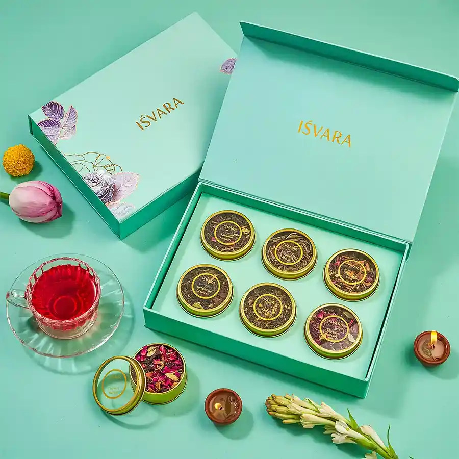 A beautifully arranged gift set featuring six handcrafted tea blends in decorative packaging, including Kashmiri Kahwah, Herb Basket, Darjeeling Green, Darjeeling Black, Spice Infused Rose Green, and Symphony of Spices.