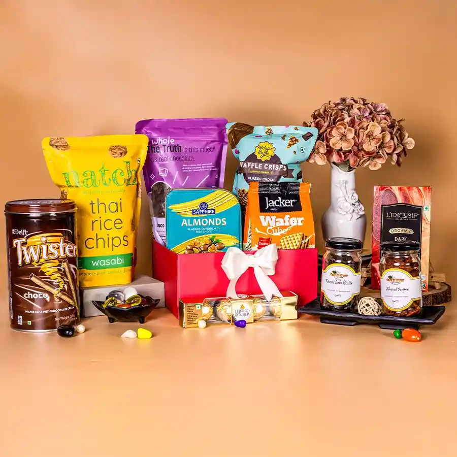 Gourmet chocolate and treats basket filled with Belgian Waffle Crisps, LExclusif Chocolate Bars, Peri Peri Almonds, and Choco Fruit Muesli on a wooden background.