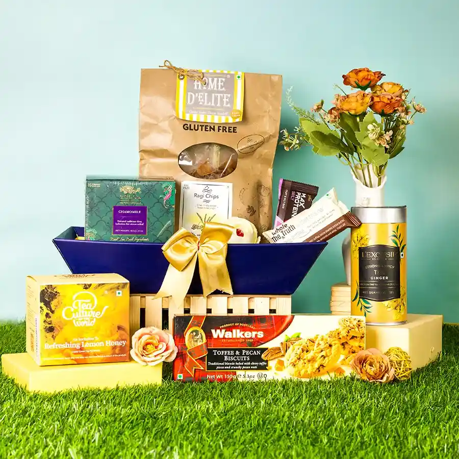 Decadent Tea N Treats Gift Hamper featuring assorted biscuits, tea, chips, and protein bars