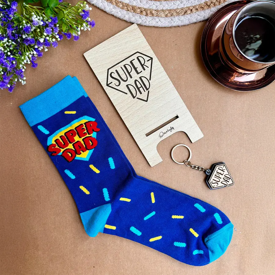 Super Dad Socks and Wooden Accessories Gift Set including superhero-themed socks, a wooden keychain, and a wooden mobile stand neatly packaged.