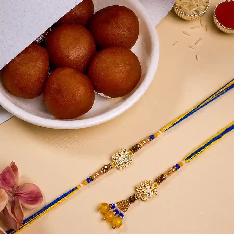 Festive Kundan Bhai Bhabhi Rakhi with Gulab Jamun combo alongside Roli Tika, Chawal, and a message card
