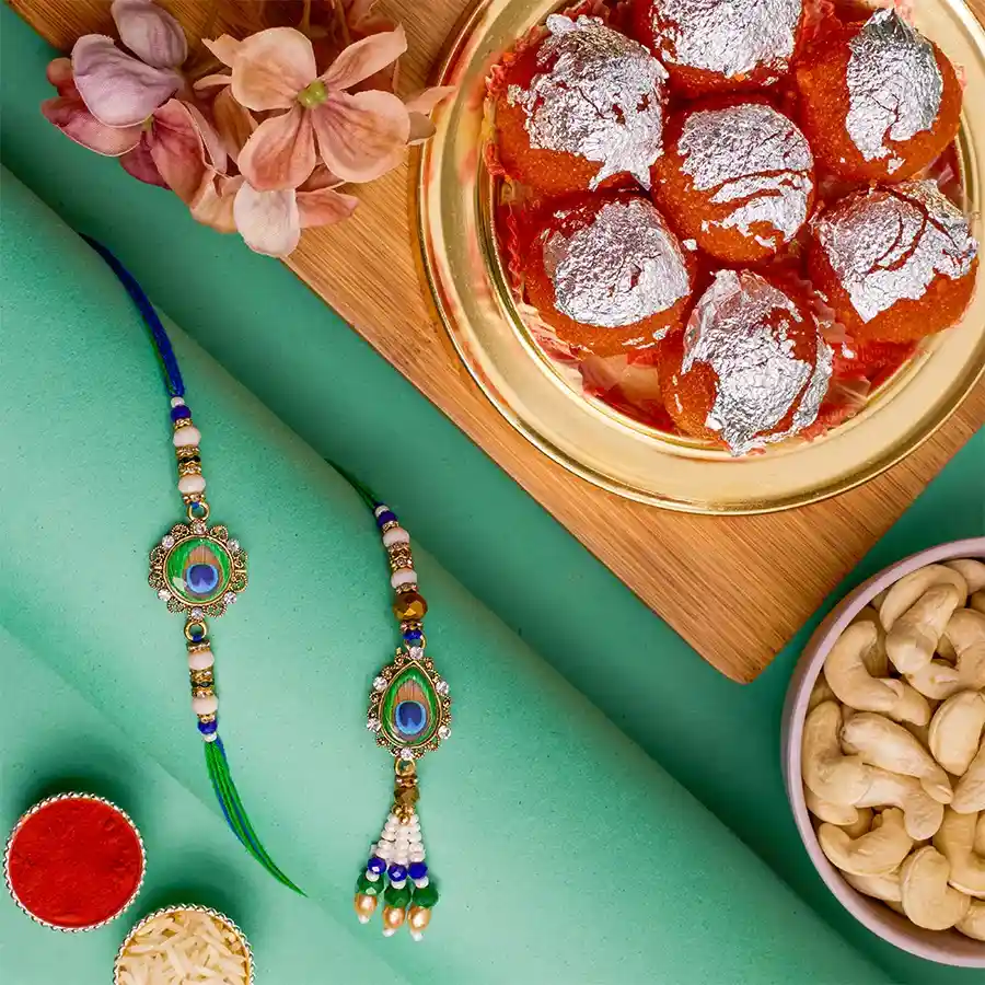 Stylish Bhai Bhabhi Rakhi N Treats Combo with Rakhis, Ghee Laddus, premium cashews, Roli, Tika, Chawal, and a heartfelt message card.