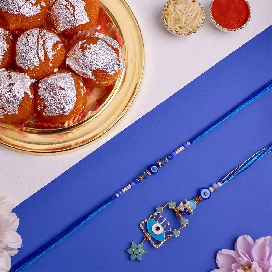 Protective Evil Eye Bhai Bhabhi Rakhi and Ghee Laddu Duo with Roli Tika, Chawal, free Rakhi, and message card