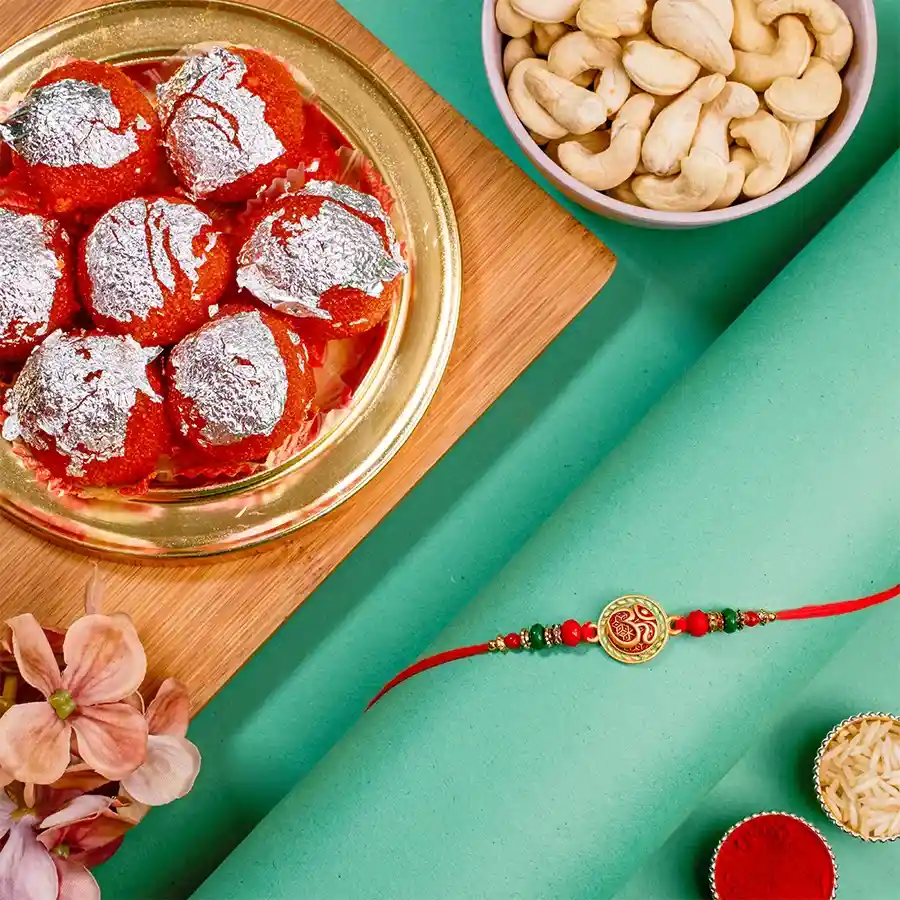 Divine OM Rakhi with Ghee Laddus, Cashews, Roli Tika, Chawal, and a message card