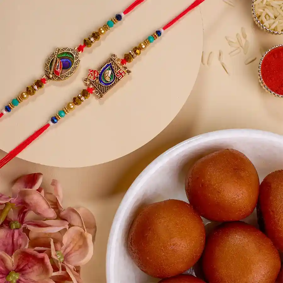 Rakhi Joy Combo featuring two Kundan Rakhis and a box of Gulab Jamuns with Roli, Tika, Chawal, and a message card