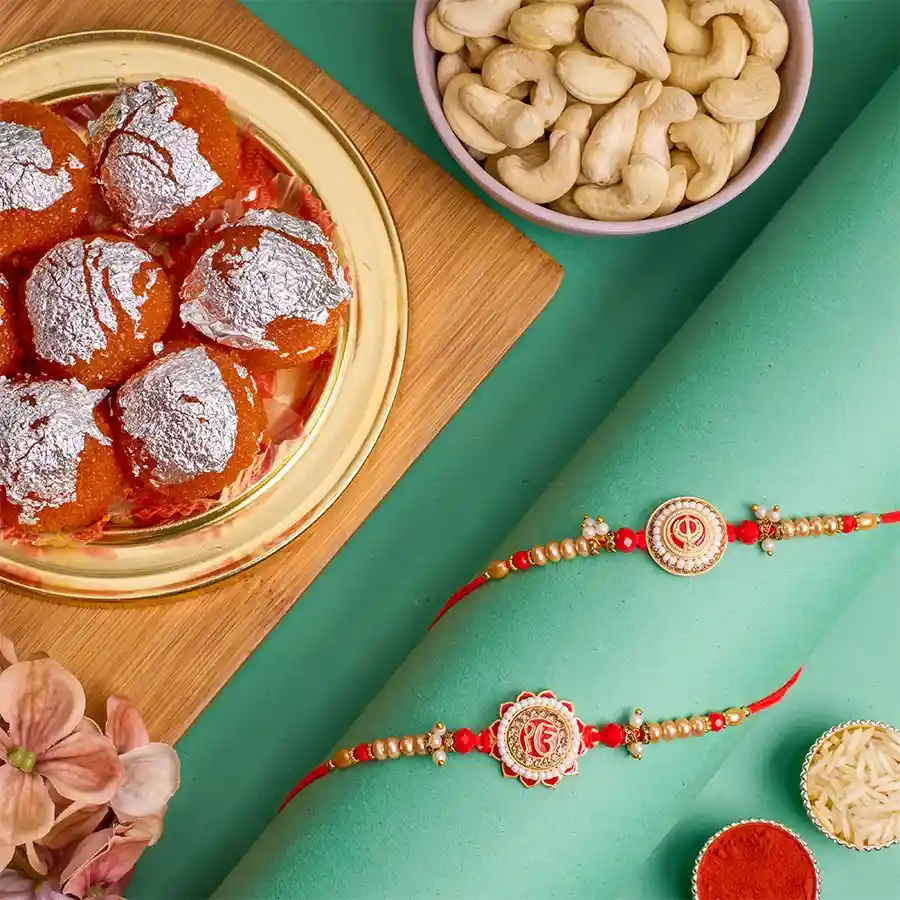 Stylish Punjabi Rakhi and Treats Combo featuring EK Onkaar and Khanda Rakhis, ghee laddus, premium cashews, and complimentary roli tika and chawal.