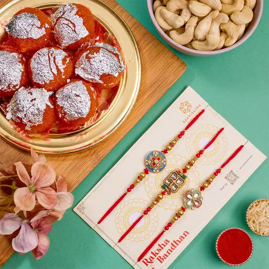 Premium Rakhi N Treats Combo featuring 3 Kundan Rakhis, 500g Ghee Laddu, 100g cashews, Roli, Tika, Chawal, a free message card, and an extra Rakhi.