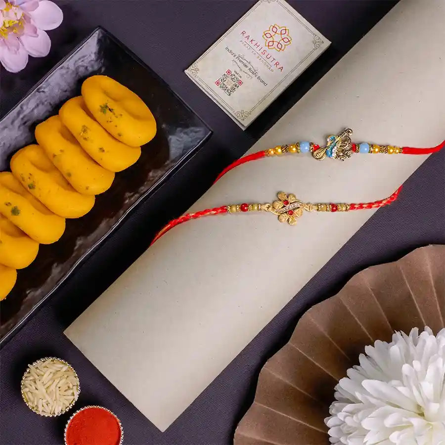 Premium Kundan Rakhis with Kesar Peda Combo featuring two elegant Rakhis, 100g of Kesar Peda, and complimentary traditional items.