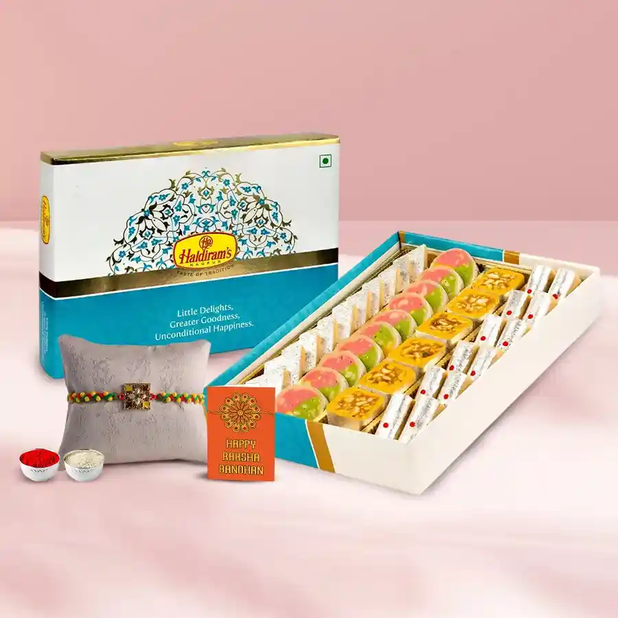 Haldirams Assorted Sweets N Thali gift package featuring sweets, a Rakhi, Roli Tilak, and chawal, beautifully wrapped for Rakhi celebrations.