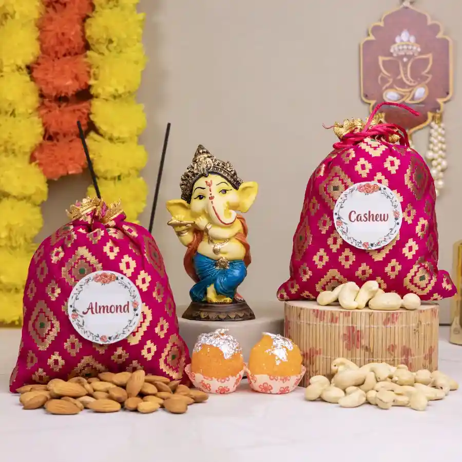 Festive Nut Potli and Ganesh Decor Combo featuring cashew and almond potlis, a Dancing Ganesh showpiece, and laddu candles