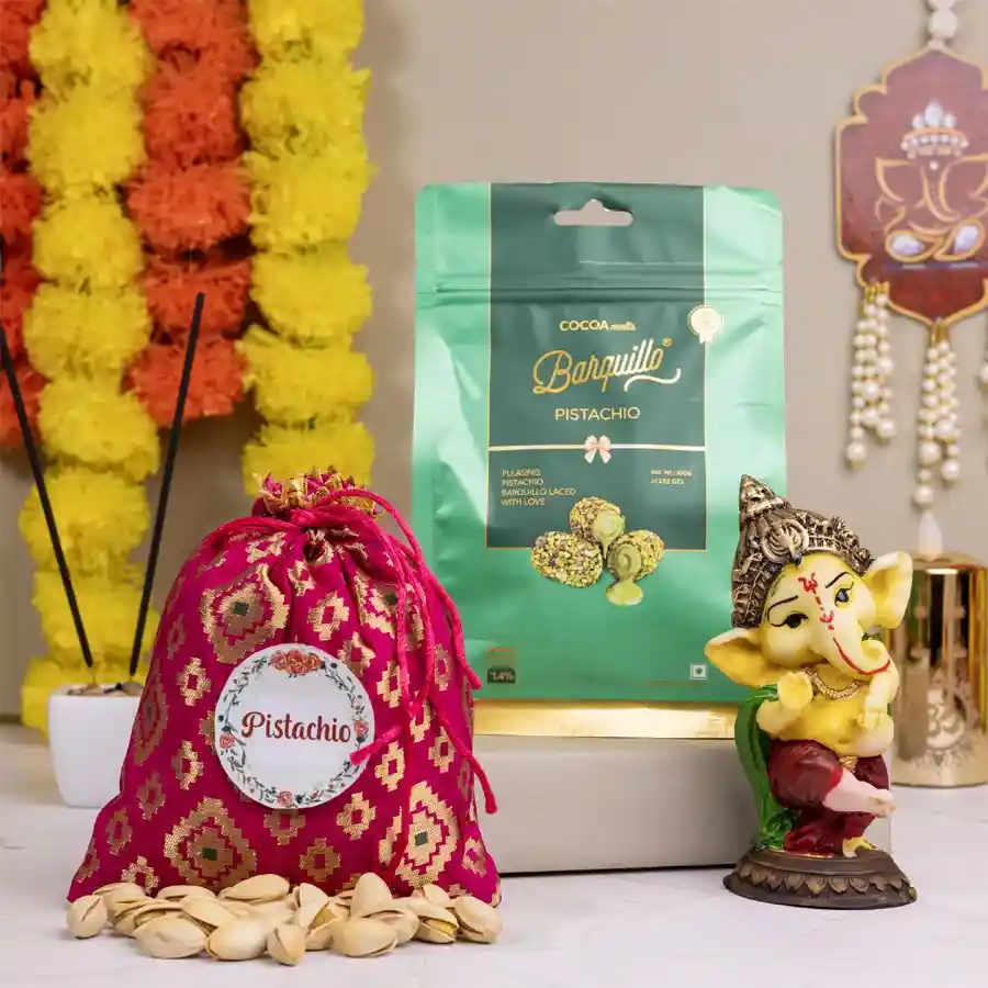 Ganesh showpiece figurine with a potli of pistachios and pistachio-coated chocolates arranged together