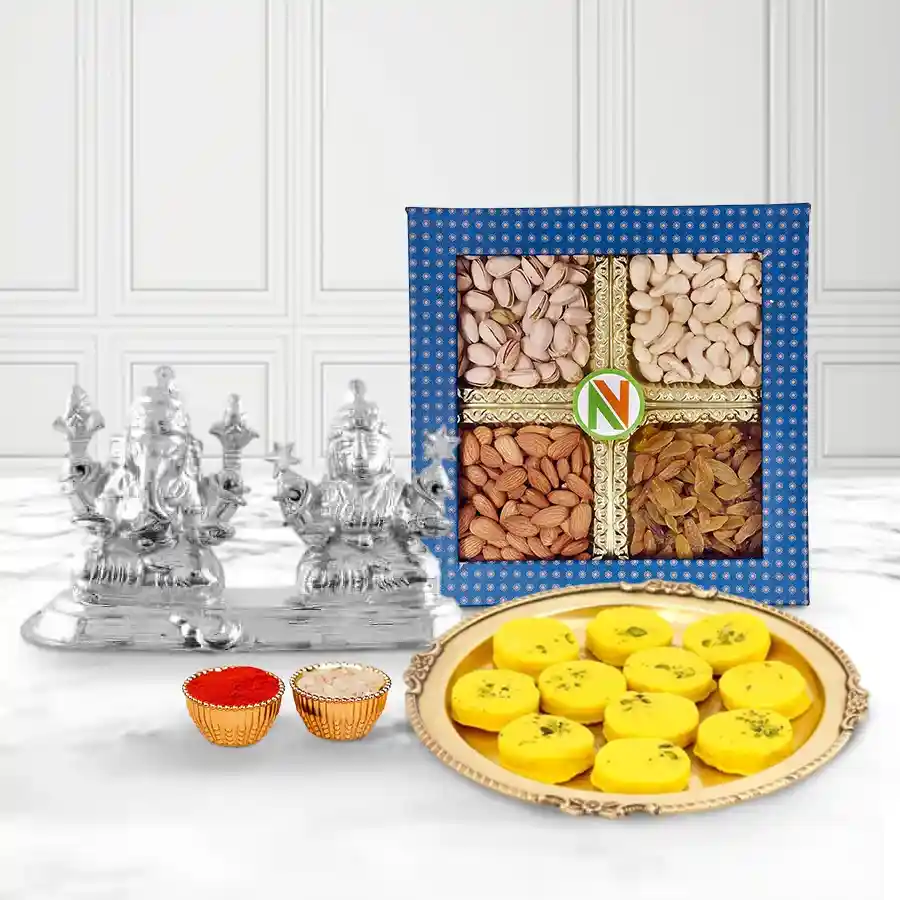 Dry fruits assortment, Haldirams Kesaria Peda, and a silver-plated Ganesh Lakshmi idol in a festive gift set.