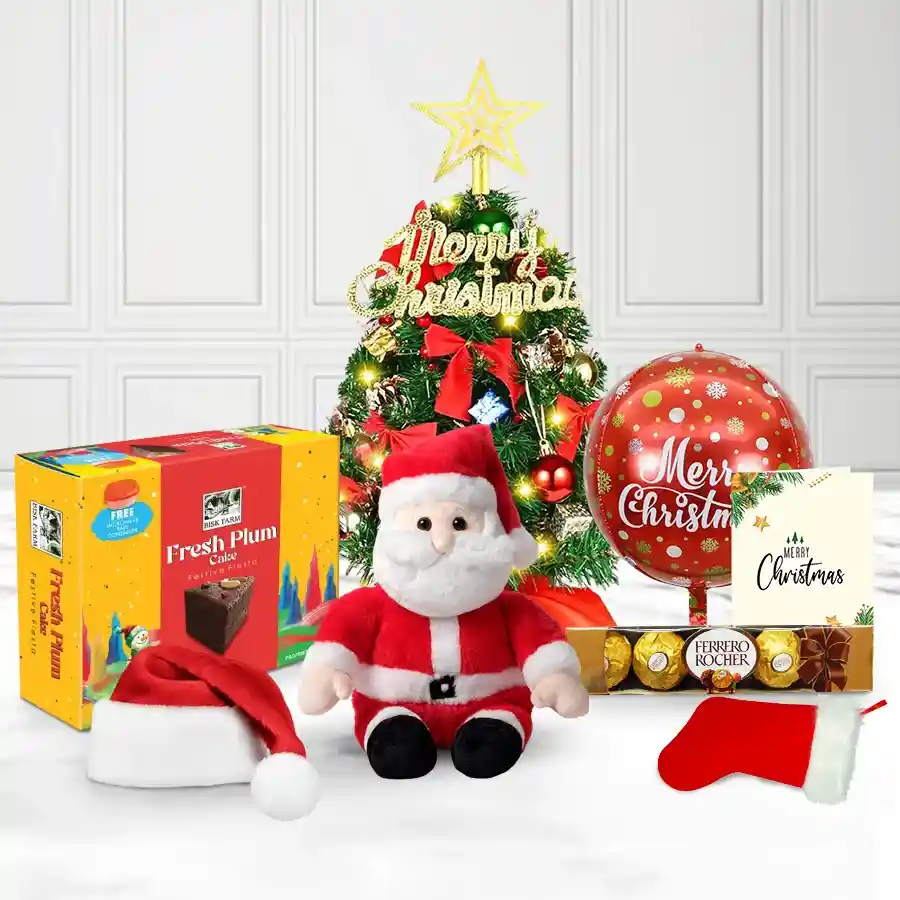 Incomparable Christmas Gift Hamper featuring a Christmas tree with Santa Claus, a Santa cap, stockings, balloons, a Christmas card, Bisk Farm Plum Cake, and Ferrero Rocher chocolates.