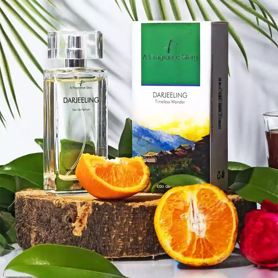 Darjeeling Perfume Fruity Tea Retreat bottle with lush tea garden and citrus fruits in the background