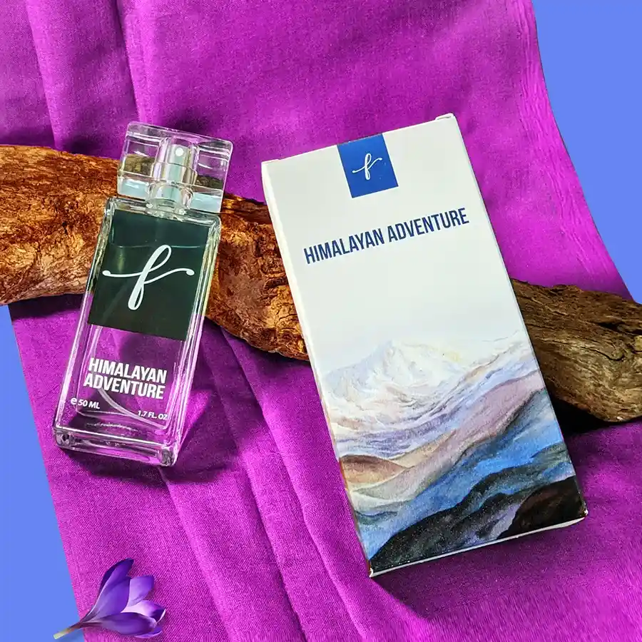 Himalayan Adventure Perfume bottle surrounded by picturesque mountain scenery and floral elements.