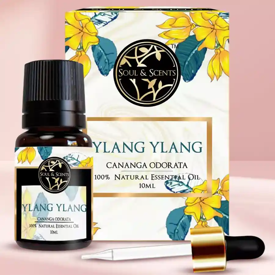 Aromatherapy Delight Ylang Ylang Essential Oil bottle on a wooden surface with flowers in the background.