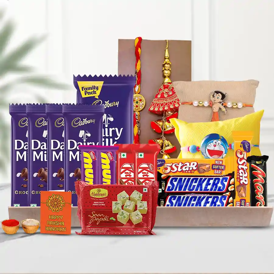 Family Rakhi N Choco Delights gift box featuring chocolates, Soan Papdi, a Family Rakhi Set, a message card, Roli Tika, Chawal, and a wooden tray.