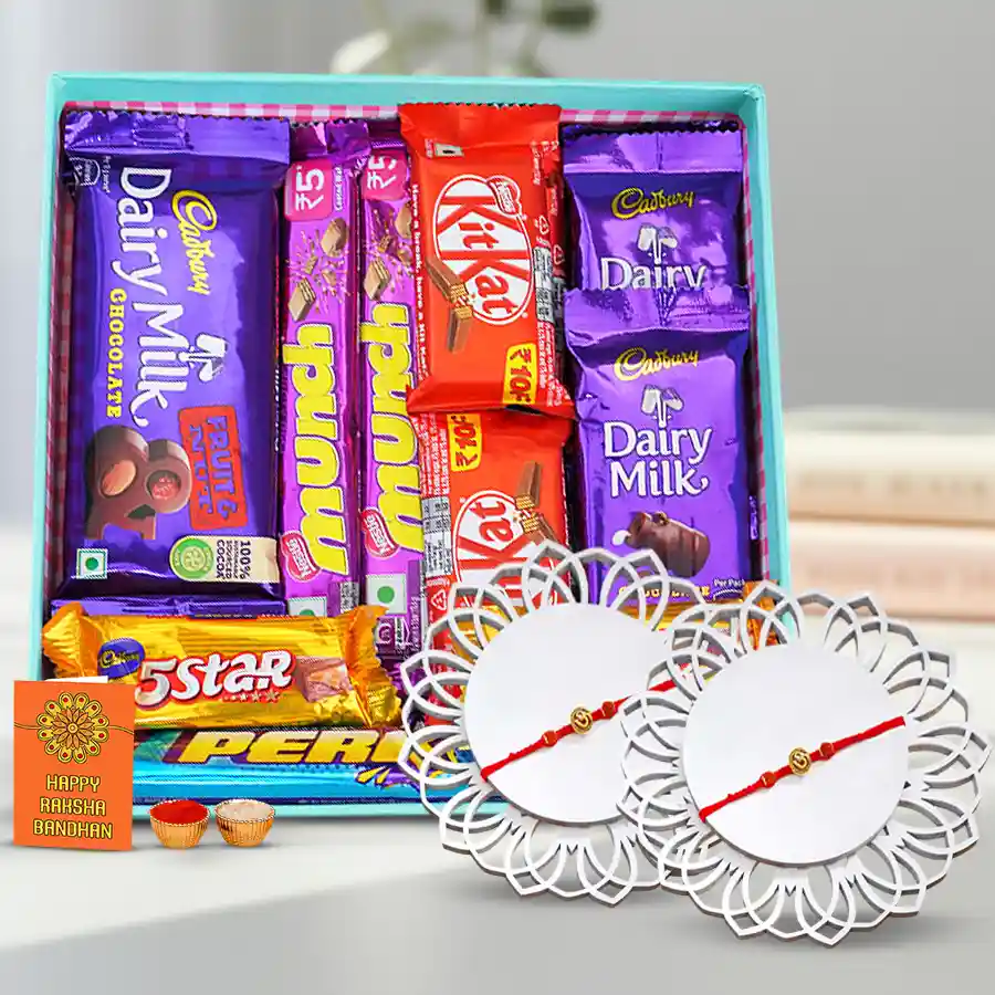 Om Rakhi pair with a basket of chocolates including Cadbury Dairy Milk, Nestle Munch, and Kit Kat, accompanied by Roli, Tilak, and Chawal set.
