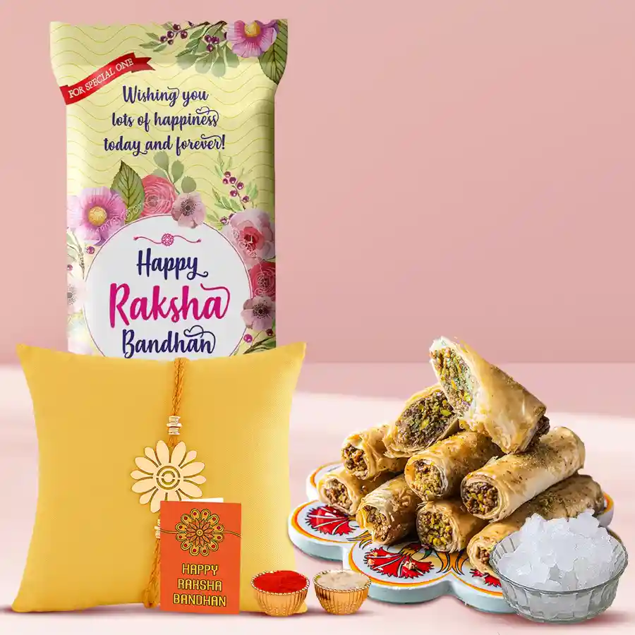 Personalized Chocolate Menia with metal Rakhi, featuring Cadbury Dairy Milk chocolate, Roll Baklawa box, sweet Mishri, and a Rakhi set with Roli, Tika, and Chawal.