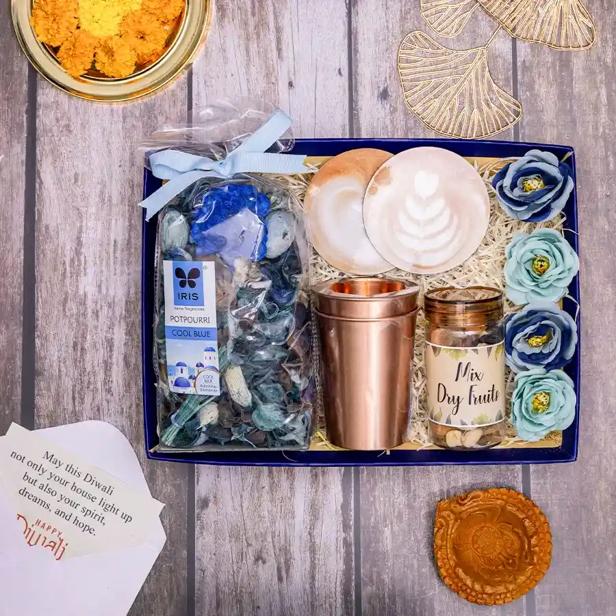 Copper Elegance Festive Set featuring two copper glasses, a mud diya, elegant coasters, a mix of dry fruits, and Irish potpourri presented in a reusable basket.