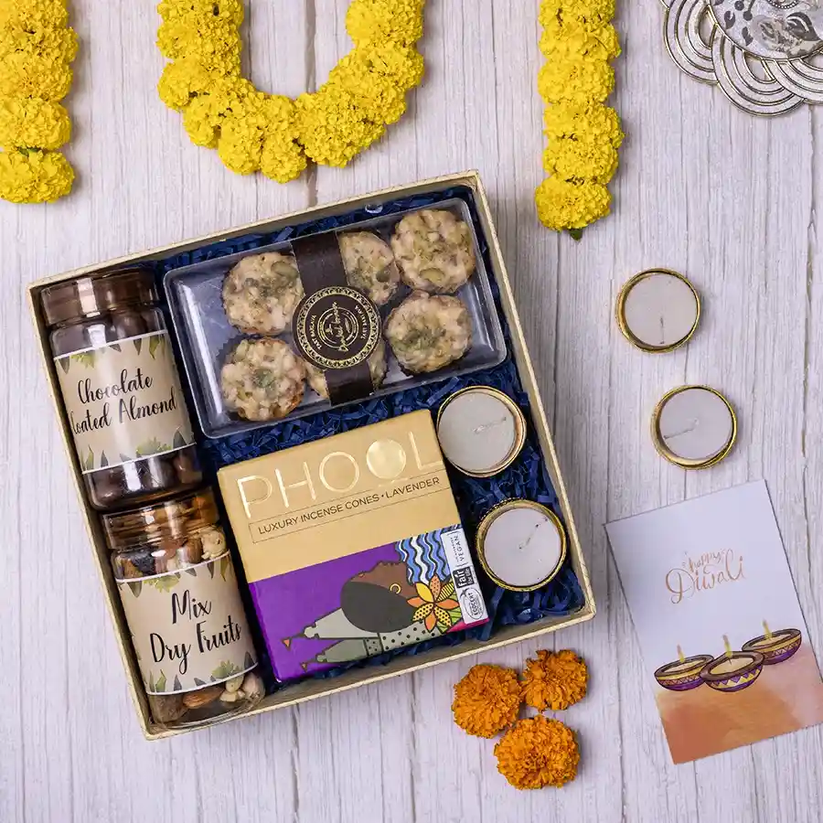 Diwali Gourmet Delights and Aroma Duo hamper featuring chocolate-coated almonds, dry fruits, Dunkel Braun Tart Baklava, incense cones, and tea light candles in a reusable gift box.