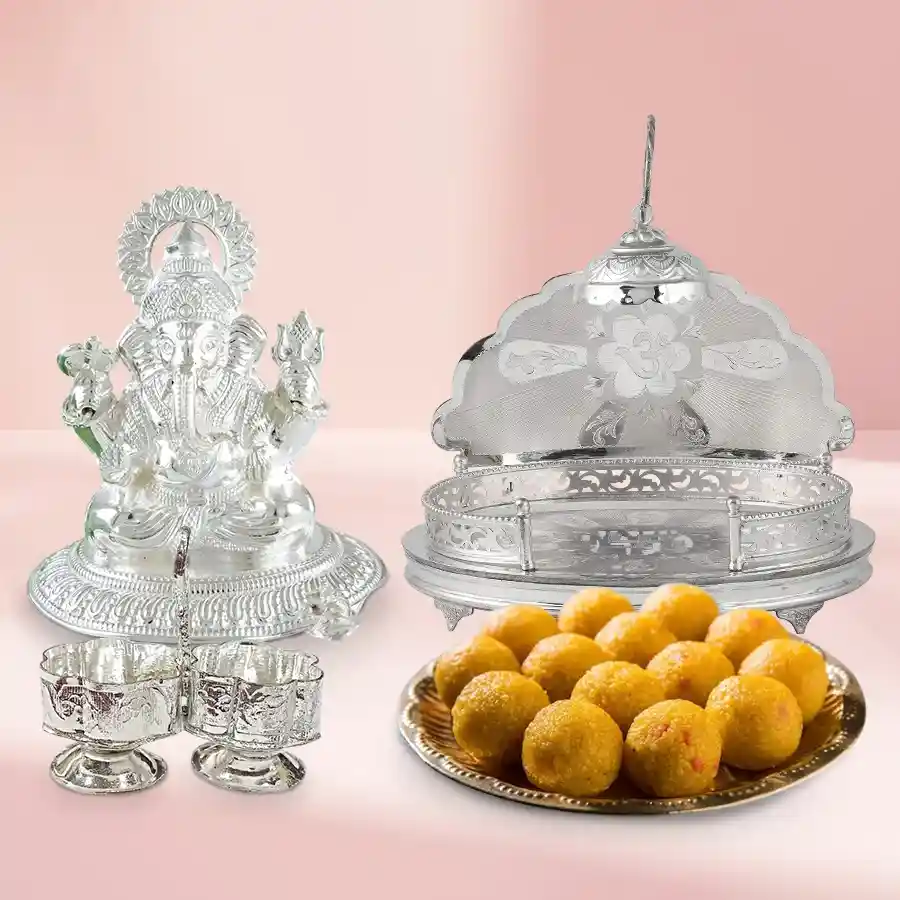 Divine Wishes Gift Pack featuring a Pure Silver Ganesh Idol, silver-plated Haldi and Kumkum stand, silver-plated Mandir, and Pure Ghee Ladoos.
