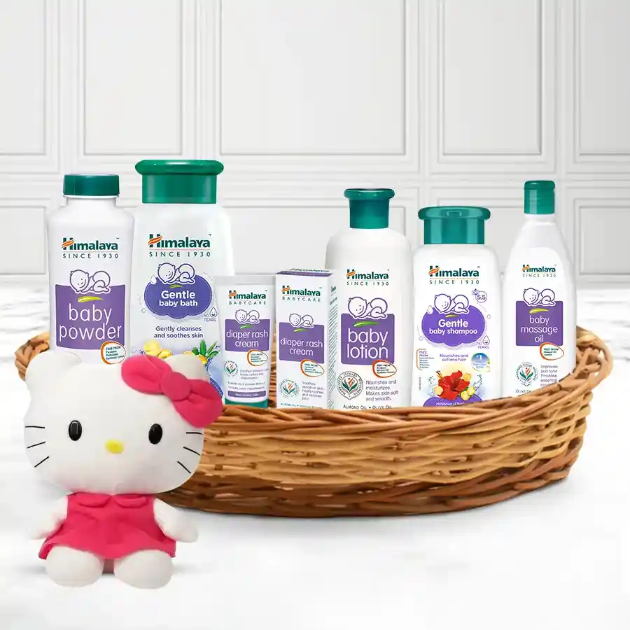 Himalaya Baby Care Gift Set featuring baby essentials and a kitty stuffed toy in a reusable cane basket.