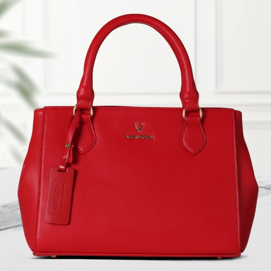 A vibrant red faux leather vanity bag for women with stylish bottom belt design and two compartments.